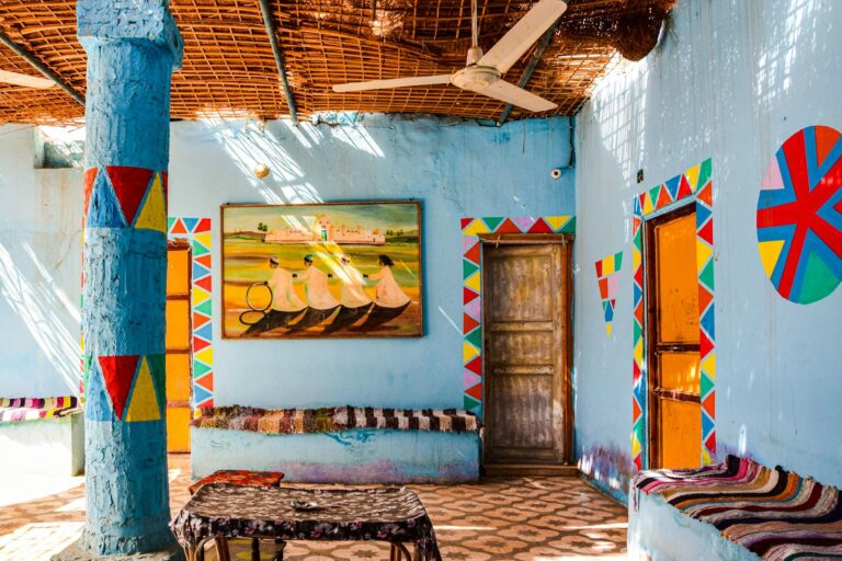 Colorful Nubian style interior with ornate patterns and sunlight streaming through woven roof.